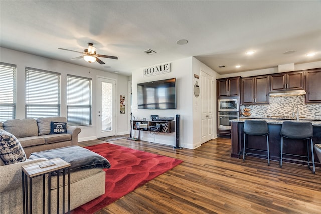 living room with ceiling fan, dark hardwood / wood-style floors, and sink