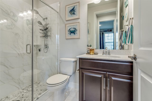 bathroom featuring vanity, a shower with shower door, and toilet