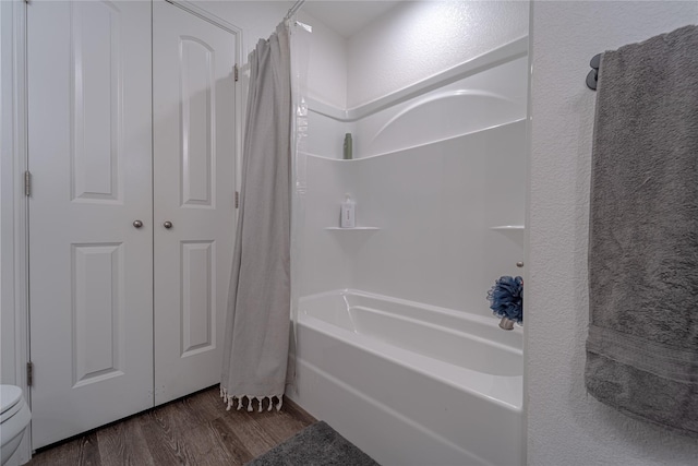 bathroom with hardwood / wood-style flooring and shower / tub combo