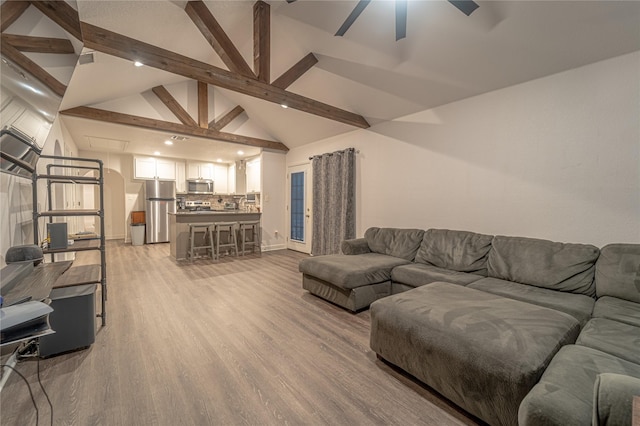 living room featuring beamed ceiling, ceiling fan, high vaulted ceiling, and light hardwood / wood-style floors