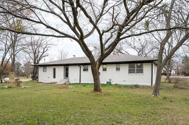 rear view of property featuring a lawn