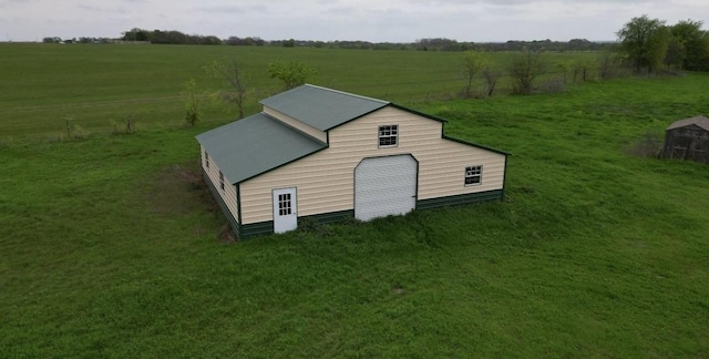 view of outbuilding featuring a yard and a rural view