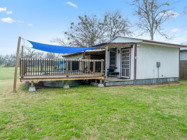 back of house featuring a wooden deck and a yard