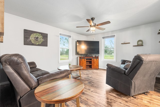 living room with wood-type flooring, ceiling fan, and plenty of natural light