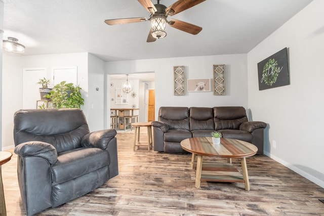 living room featuring wood-type flooring and ceiling fan