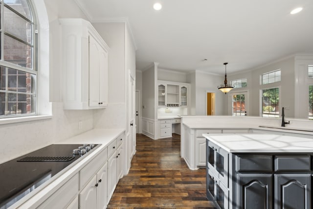 kitchen with decorative light fixtures, sink, and white cabinets