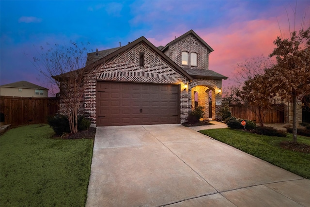 view of front of house with driveway, a garage, fence, a front lawn, and brick siding