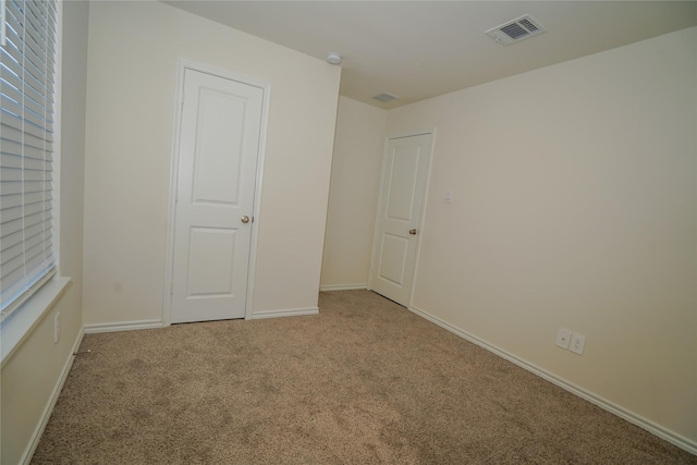 spare room featuring light colored carpet