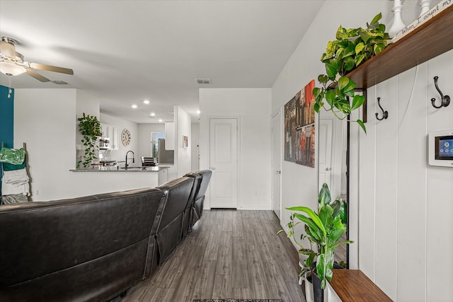 living room featuring ceiling fan, sink, and hardwood / wood-style floors