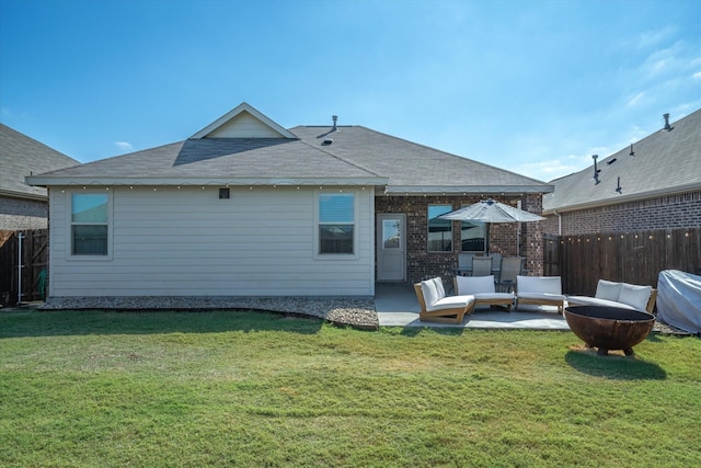 rear view of property with a patio, an outdoor living space with a fire pit, and a lawn