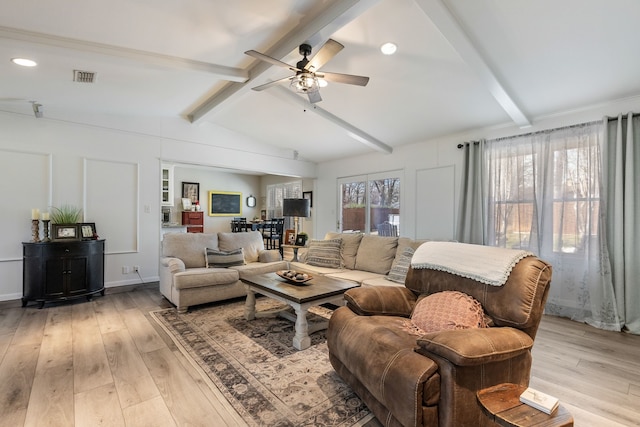 living room with vaulted ceiling with beams, light hardwood / wood-style floors, and a healthy amount of sunlight