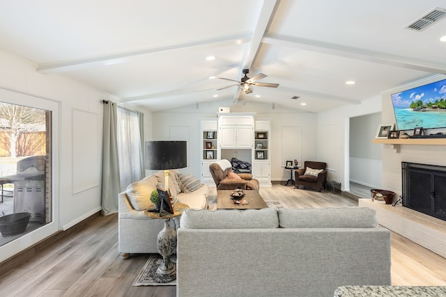 living room featuring vaulted ceiling with beams and light hardwood / wood-style floors