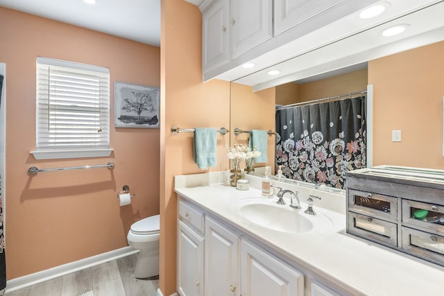 bathroom with hardwood / wood-style flooring, vanity, and toilet