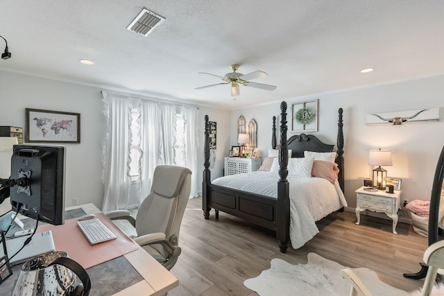 bedroom featuring ceiling fan, ornamental molding, light hardwood / wood-style flooring, and a textured ceiling