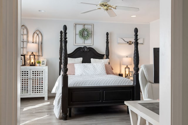 bedroom featuring crown molding, wood-type flooring, and ceiling fan