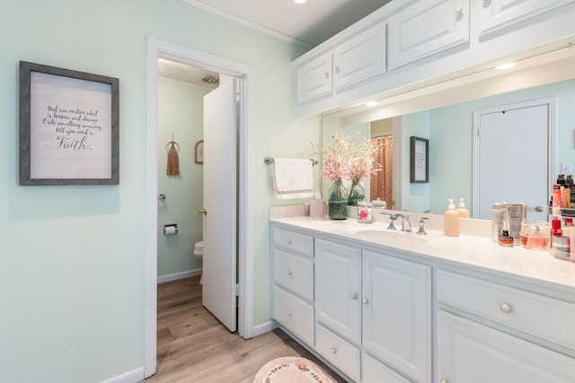 bathroom featuring ornamental molding, vanity, toilet, and hardwood / wood-style floors