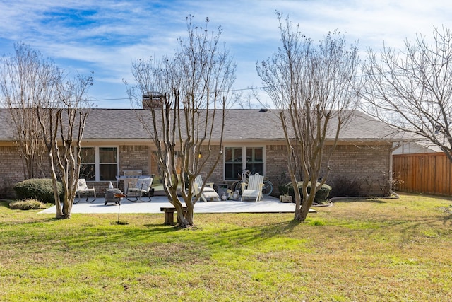 rear view of property with a lawn and a patio