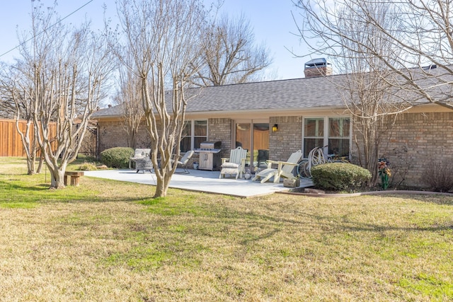 back of property with a yard and a patio