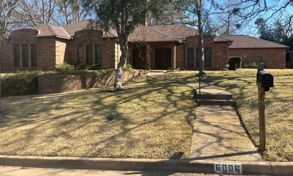 ranch-style home featuring a front yard