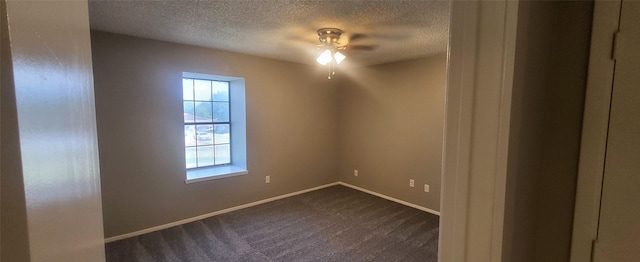 spare room with a textured ceiling, ceiling fan, carpet flooring, and baseboards