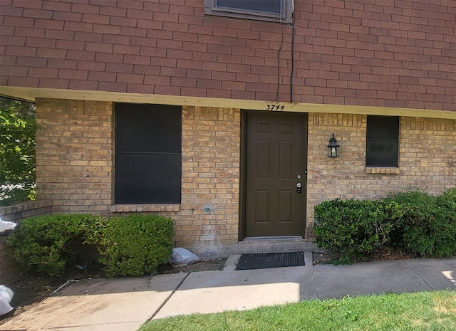 property entrance featuring a shingled roof