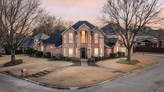 view of front facade featuring driveway and brick siding