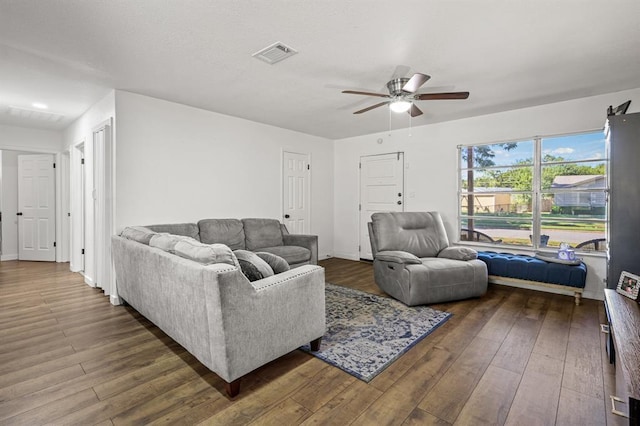 living room featuring ceiling fan and dark hardwood / wood-style flooring