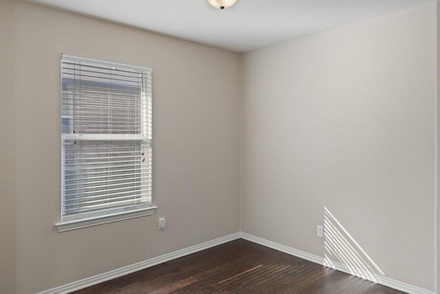 empty room with baseboards and dark wood finished floors