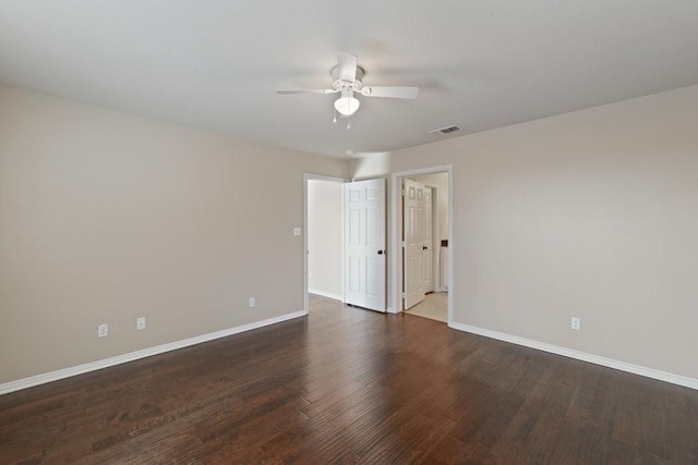 spare room featuring baseboards, a ceiling fan, visible vents, and wood finished floors