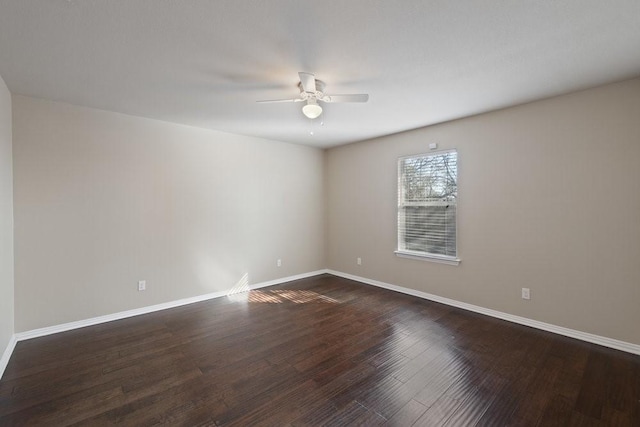 spare room with dark wood-type flooring, baseboards, and a ceiling fan