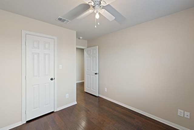 unfurnished bedroom with baseboards, dark wood-style flooring, visible vents, and a ceiling fan