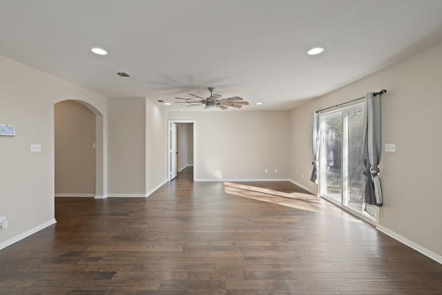 unfurnished room featuring a ceiling fan, visible vents, dark wood-style flooring, arched walkways, and recessed lighting