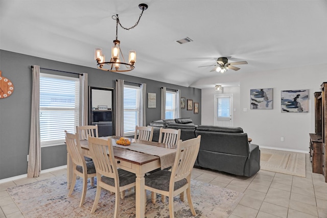 tiled dining space with lofted ceiling, ceiling fan with notable chandelier, and plenty of natural light