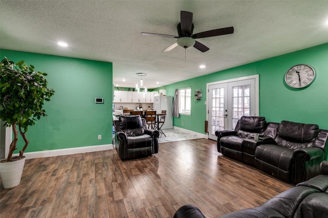 living room with hardwood / wood-style flooring, ceiling fan, a textured ceiling, and french doors