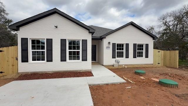 single story home featuring fence