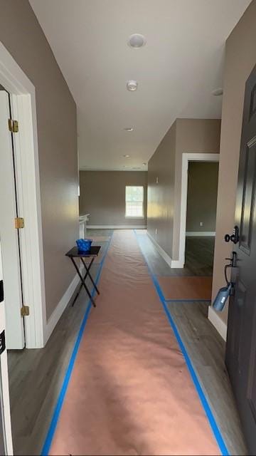 corridor featuring baseboards and wood finished floors