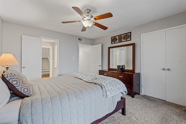 living room featuring wood finished floors, ceiling fan, a fireplace, a high ceiling, and visible vents