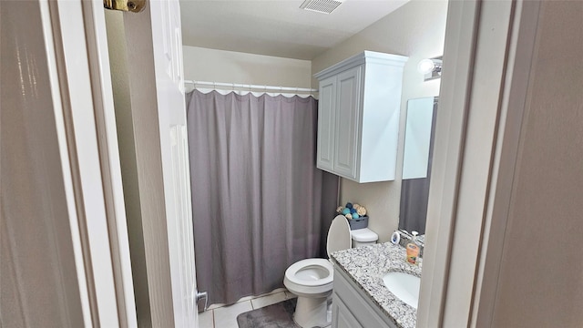 bathroom with tile patterned flooring, vanity, and toilet