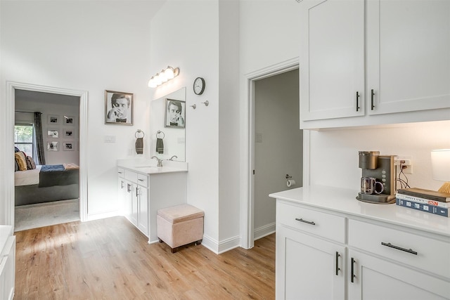 517 Ramon St, Burleson, TX 76028 - kitchen with light wood-type flooring, light countertops, and white cabinets