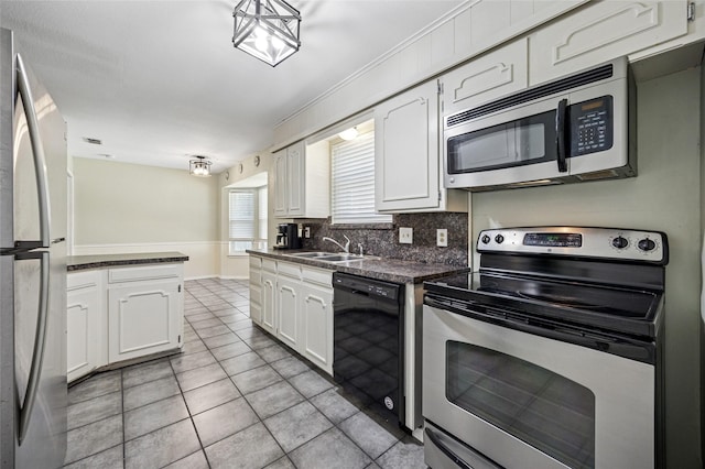 7316 Martha Ln, Fort Worth, TX 76112 - kitchen with appliances with stainless steel finishes, dark countertops, white cabinetry, and light tile patterned floors