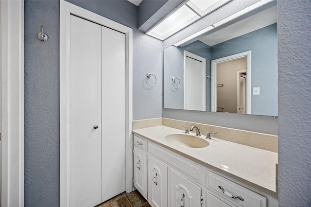 7316 Martha Ln, Fort Worth, TX 76112 - bathroom with vanity, a textured wall, and wood finished floors