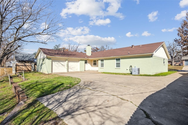 7316 Martha Ln, Fort Worth, TX 76112 - rear view of house with driveway, a chimney, a garage, and central AC