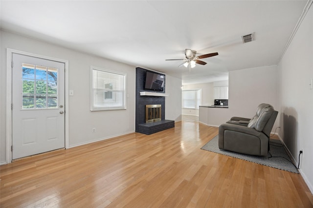 7316 Martha Ln, Fort Worth, TX 76112 - unfurnished living room featuring light wood-style floors, a ceiling fan, baseboards, and a brick fireplace