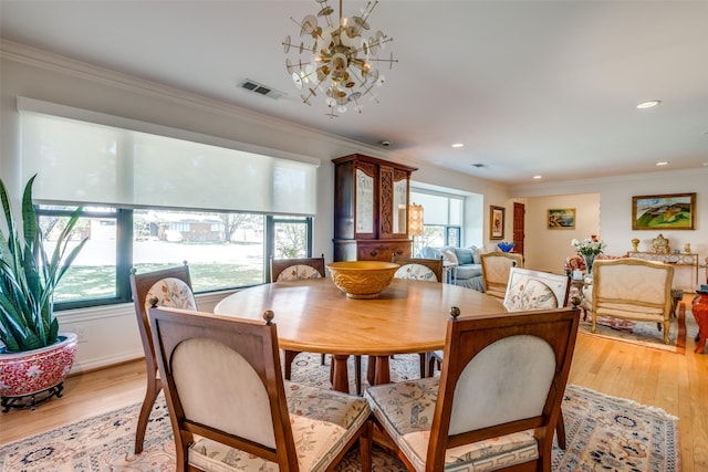 dining area featuring crown molding and light hardwood / wood-style floors