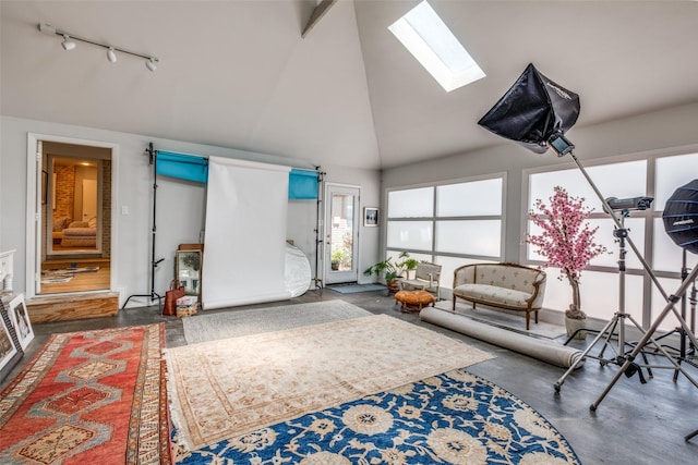 interior space with rail lighting, high vaulted ceiling, and a skylight