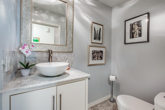 bathroom with toilet, backsplash, and vanity