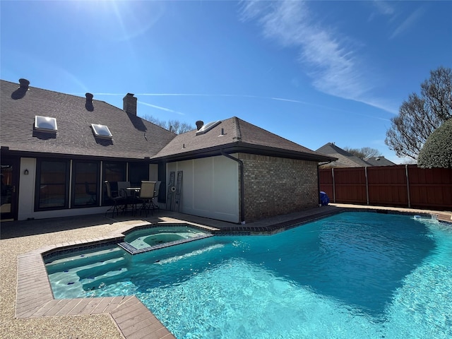 view of pool with a pool with connected hot tub, a patio, and fence