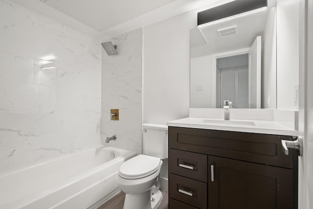 full bathroom featuring tiled shower / bath combo, vanity, and toilet