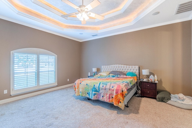 bedroom with a tray ceiling, light carpet, crown molding, and ceiling fan