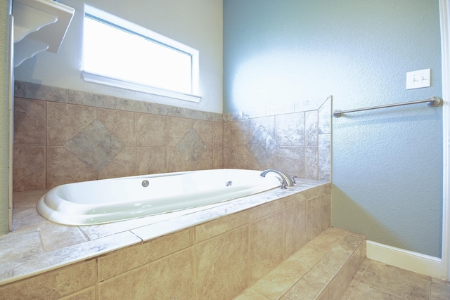 bathroom featuring tile patterned floors and a relaxing tiled tub